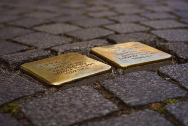 Two engraved golden plaques on bricks in outdoor pathway